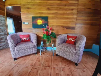 two chairs and a table in a room with wooden walls at Cabaña Rural Ave del Paraíso in Fortuna