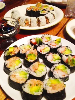 a white plate of sushi on a wooden table at Jungle Lodge at Wild Sun Rescue Center in Cabuya