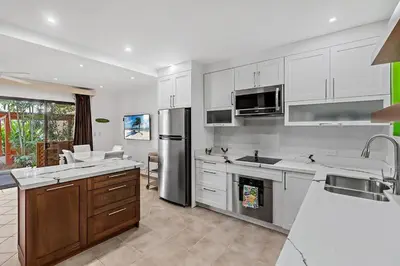 a kitchen with white cabinets and stainless steel appliances at Colorful & Private 2-Bedroom Condo Just a Short Walk from the Beach in Coco