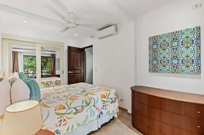 a bedroom with a bed and a painting on the wall at Colorful & Private 2-Bedroom Condo Just a Short Walk from the Beach in Coco