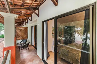 a room with a bed and a table and chairs at Colorful & Private 2-Bedroom Condo Just a Short Walk from the Beach in Coco