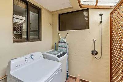a laundry room with a washing machine and a window at Colorful & Private 2-Bedroom Condo Just a Short Walk from the Beach in Coco