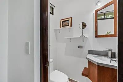 a bathroom with a sink and a toilet and a mirror at Colorful & Private 2-Bedroom Condo Just a Short Walk from the Beach in Coco