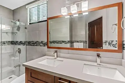 a bathroom with two sinks and a shower and a mirror at Colorful & Private 2-Bedroom Condo Just a Short Walk from the Beach in Coco