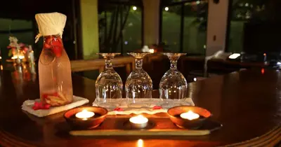 a table with candles and wine bottles on a table at Arenal Paraiso Resort Spa & Thermo Mineral Hot Springs in Fortuna