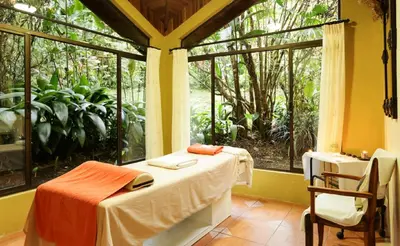 a room with a bed and a large window at Arenal Paraiso Resort Spa & Thermo Mineral Hot Springs in Fortuna