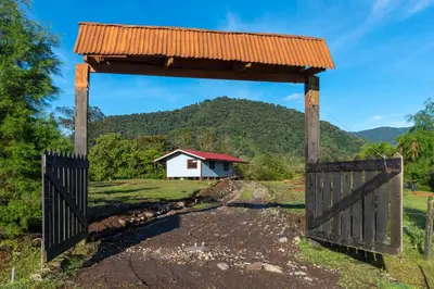 an open gate with a house in the background at Calas Lodge in Bajos del Toro