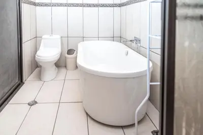 a bathroom with a toilet and a bath tub at Calas Lodge in Bajos del Toro