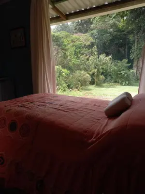 a bed with a red comforter in front of a window at Suite y Loft Casa Toría in San Isidro
