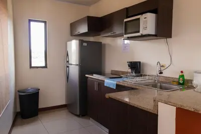a kitchen with a stainless steel refrigerator and a sink at Aptos Casa Caribe, habitaciones privadas en aptos compartidos & aptos completos con auto entrada in Puerto Limón