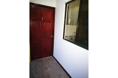 a room with a red door and a window at Aptos Casa Caribe, habitaciones privadas en aptos compartidos & aptos completos con auto entrada in Puerto Limón