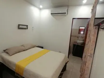a small bedroom with a bed and a bathroom at Aptos Casa Caribe, habitaciones privadas en aptos compartidos & aptos completos con auto entrada in Puerto Limón