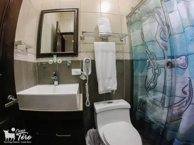 a bathroom with a toilet and a sink and a mirror at Casas del Toro Playa Flamingo in Playa Flamingo