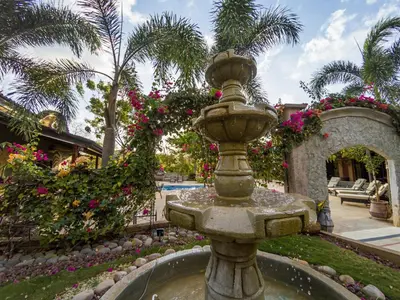 a fountain in the middle of a courtyard with flowers at Casas del Toro Playa Flamingo in Playa Flamingo