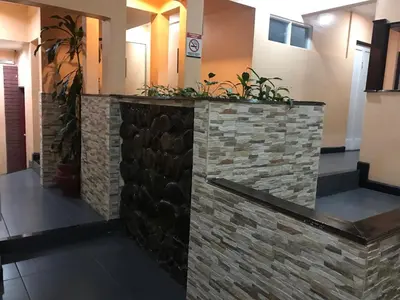 a lobby with a stone wall with plants at La Bergerac Boutique Hotel in San José