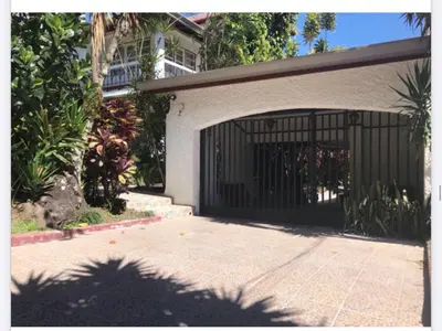 a garage with a black gate in front of a building at La Bergerac Boutique Hotel in San José