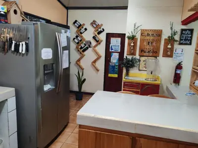 a kitchen with a refrigerator and a counter at Cabinas El Pueblo B&B Monteverde in Monteverde Costa Rica
