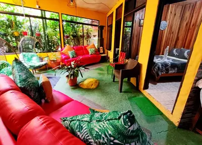 a living room with a red leather couch in a room at Cabinas El Pueblo B&B Monteverde in Monteverde Costa Rica