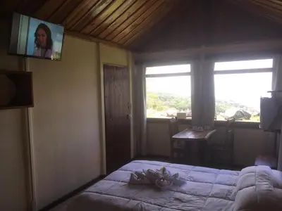 a bedroom with a bed and a tv on the wall at Bella Vista Lodge in Monteverde Costa Rica