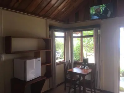 a small room with a table and a tv and a window at Bella Vista Lodge in Monteverde Costa Rica