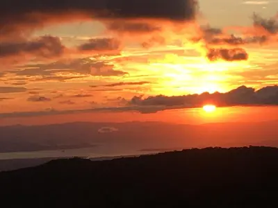 a sunset with the sun setting over the ocean at Bella Vista Lodge in Monteverde Costa Rica