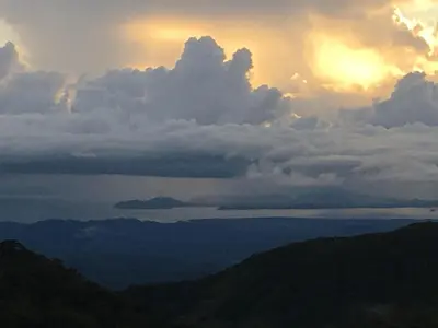 a sunset over the ocean with clouds and mountains at Bella Vista Lodge in Monteverde Costa Rica