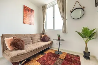 a living room with a couch and a window at Boho Chic, Apart- condo cerca de SJO Intl airport in Barrial