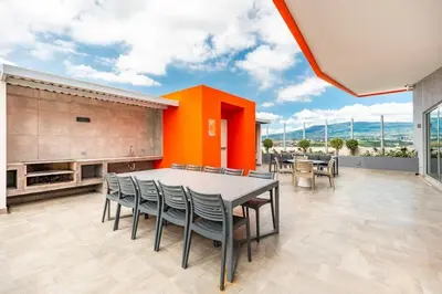 a dining room with a table and chairs at Boho Chic, Apart- condo cerca de SJO Intl airport in Barrial
