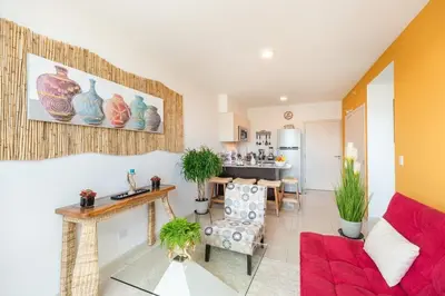 a living room with a red couch and a kitchen at Boho Chic, Apart- condo cerca de SJO Intl airport in Barrial