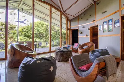 a living room with chairs and a large window at Moon Wonders Vacation House in Monteverde Costa Rica