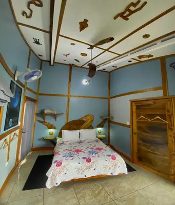 a bedroom with a bed and a ceiling with drawings on it at Moon Wonders Vacation House in Monteverde Costa Rica