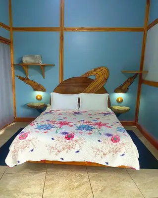 a bedroom with a bed and a blue wall at Moon Wonders Vacation House in Monteverde Costa Rica