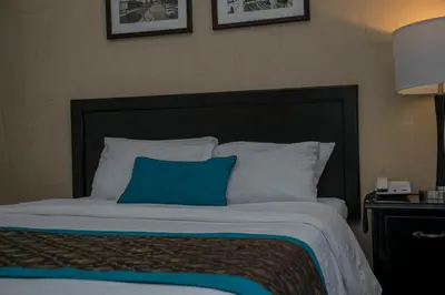 a bed with a blue pillow on top of it at Hotel Colonial in San José