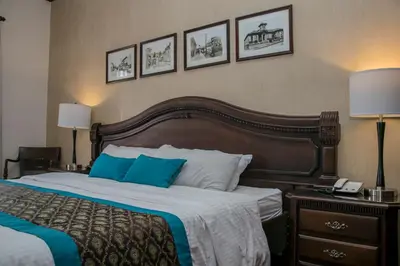 a bedroom with a large bed with blue pillows at Hotel Colonial in San José