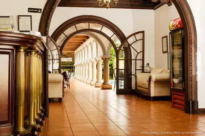 an archway in a building with chairs and tables at Hotel Colonial in San José