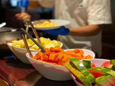 a person preparing food on a counter with bowls of food at Hacienda La Pacífica Eco-Lodge in Cañas