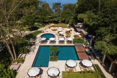 an overhead view of a pool with chairs and umbrellas at El Mangroove Papagayo, Autograph Collection in Papagayo, Guanacaste