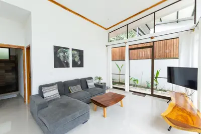 a living room with a couch and a tv at Villa Koi ~ Brand NEW Villa ~ 2 Bedrooms with Pool in Carmen