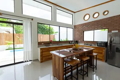 a kitchen with a table and a refrigerator at Villa Koi ~ Brand NEW Villa ~ 2 Bedrooms with Pool in Carmen