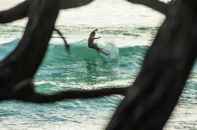 a man riding a wave on a surfboard in the ocean at Villa Koi ~ Brand NEW Villa ~ 2 Bedrooms with Pool in Carmen