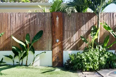 a fence in front of a yard with plants at Villa Koi ~ Brand NEW Villa ~ 2 Bedrooms with Pool in Carmen