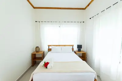 a bedroom with a white bed with a red flower on it at Villa Koi ~ Brand NEW Villa ~ 2 Bedrooms with Pool in Carmen