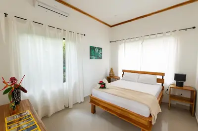 a bedroom with a bed and white curtains at Villa Koi ~ Brand NEW Villa ~ 2 Bedrooms with Pool in Carmen