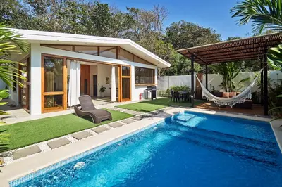 a pool with a hammock and a house at Villa Akari - Brand new 2bedrooms Villa with Pool in Carmen