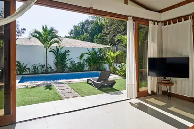 a living room with a tv and a sliding glass door at Villa Akari - Brand new 2bedrooms Villa with Pool in Carmen