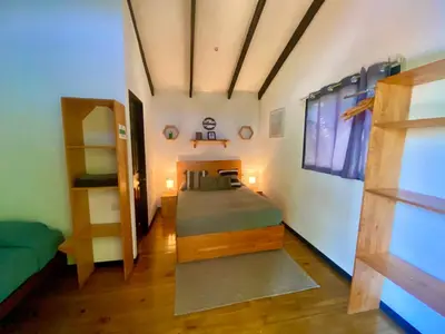 a bedroom with a bed in a room with a vaulted ceilings at Santeria Lodge in Santa Teresa Beach