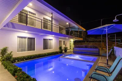 a swimming pool in front of a house at night at HOTEL MARINO BALLENA in Uvita
