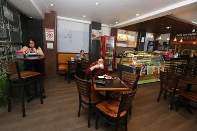 a little girl sitting at a table in a restaurant at Hotel Cultura Plaza in San José