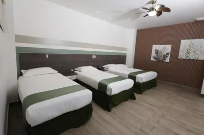 a hotel room with two beds and a ceiling fan at Hotel Cultura Plaza in San José