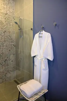 a bathroom with a shower with a white robe at Lapazul Boutique Hotel in Savegre